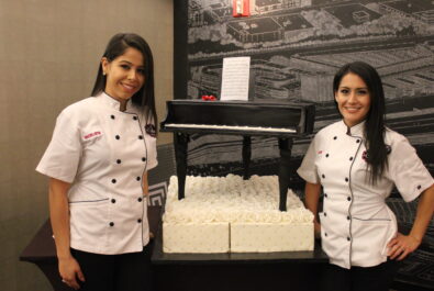 two chefs with a piano cake