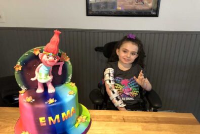 girl with a custom trolls cake