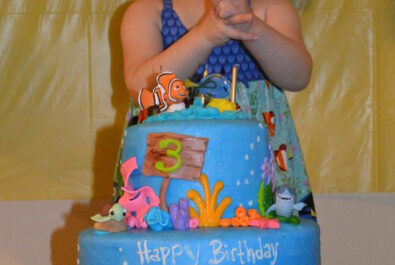 girl behind a finding nemo cake