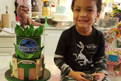 kid with a jurassic world cake