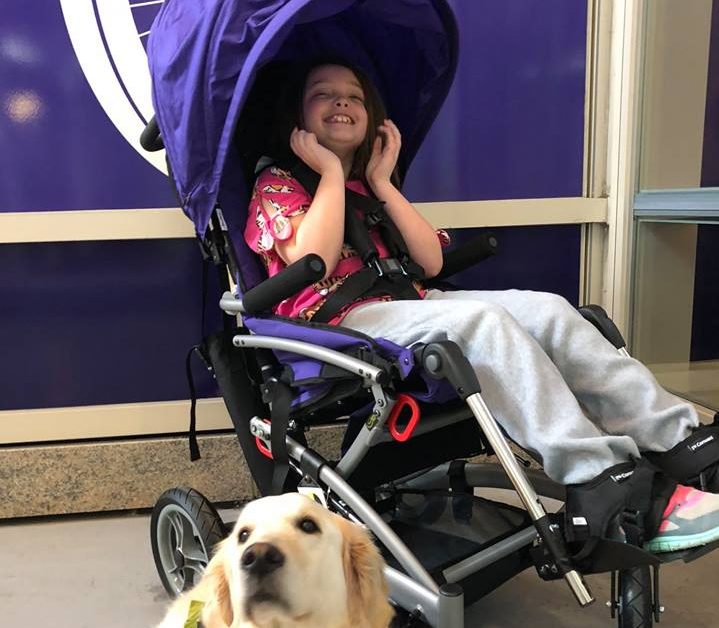 girl in a wheel chair with a dog