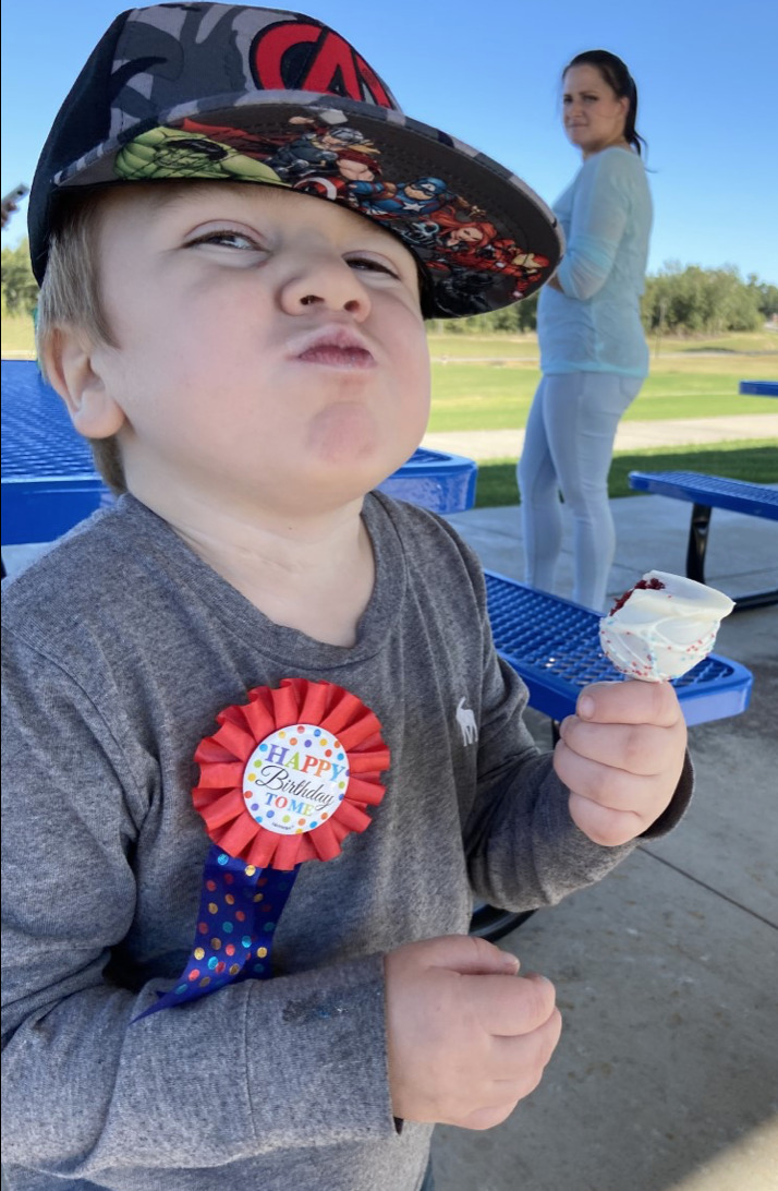 boy with a birthday ribbon in front of a woman