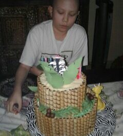 kid next to a custom cake